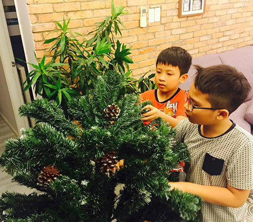 Tự tay Tê Giác ghép cây thông và treo từng món đồ trang trí lên cây.