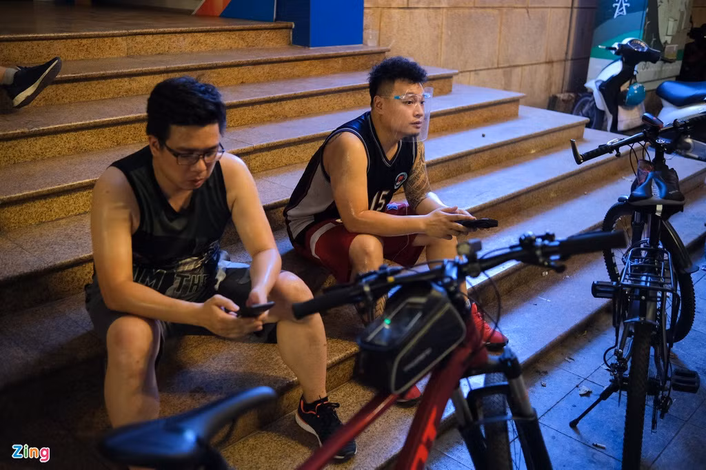 Từ 20h, Minh Đức (35 tuổi, phải) xuất phát từ nhà và đạp xe khoảng 15 km trước khi dừng chân nghỉ ở Bưu điện Thành phố. Vốn là người ưa vận động, cái nóng mùa hè cũng không thể cản anh đạp xe mỗi tối. “Sau khi ngồi lì nhà cả ngày để làm việc, tôi thấy mình cần ra đường tập thể dục, rồi về tắm và bật điều hòa ngủ ngon giấc”, anh cho biết.