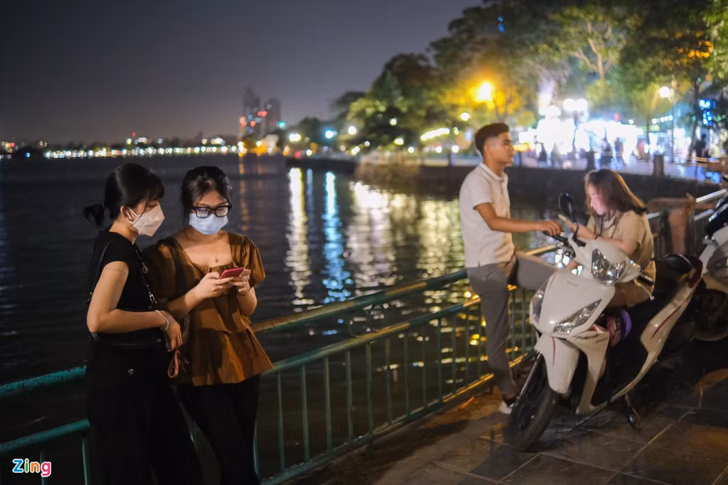 Khi hay tin ngày mai Hà Nội nới lỏng một số dịch vụ, Thu Hoài (21 tuổi, trái) và bạn cùng phòng trọ của cô, Thanh Huyền (21 tuổi), đèo nhau từ quận Cầu Giấy sang quận Tây Hồ để xem các hàng quán đã nhộn nhịp chuẩn bị trở lại chưa. Đây cũng là lần đầu tiên hai cô gái bước chân ra khỏi nhà từ hôm nhiệt độ ở thủ đô bắt đầu tăng cao.