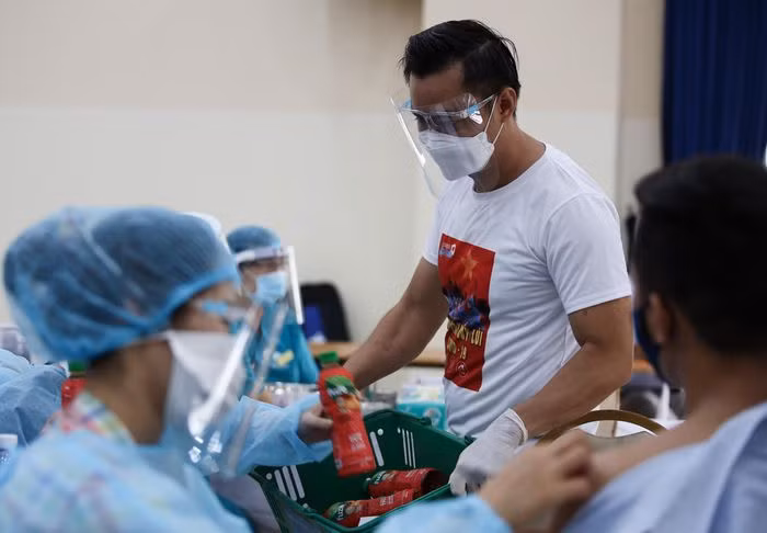 Các tình nguyện viên mang nước, trao tận tay cho từng nhân viên y tế. Mỗi đội tiêm có ít nhất 5 nhân viên có trình độ chuyên môn, gồm một bác sĩ khám sàng lọc, 2 nhân viên tiêm vaccine, một bác sĩ và một điều dưỡng phụ trách theo dõi, xử trí phản ứng sau tiêm.