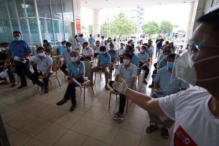 Các công nhân ngồi theo từng hàng ghế, thực hiện giãn cách, đeo khẩu trang đúng quy định. Để đảm bảo an toàn, tất cả công nhân viên đều phải đo huyết áp, khám sàng lọc trước khi tiến hành tiêm vaccine Covid-19.