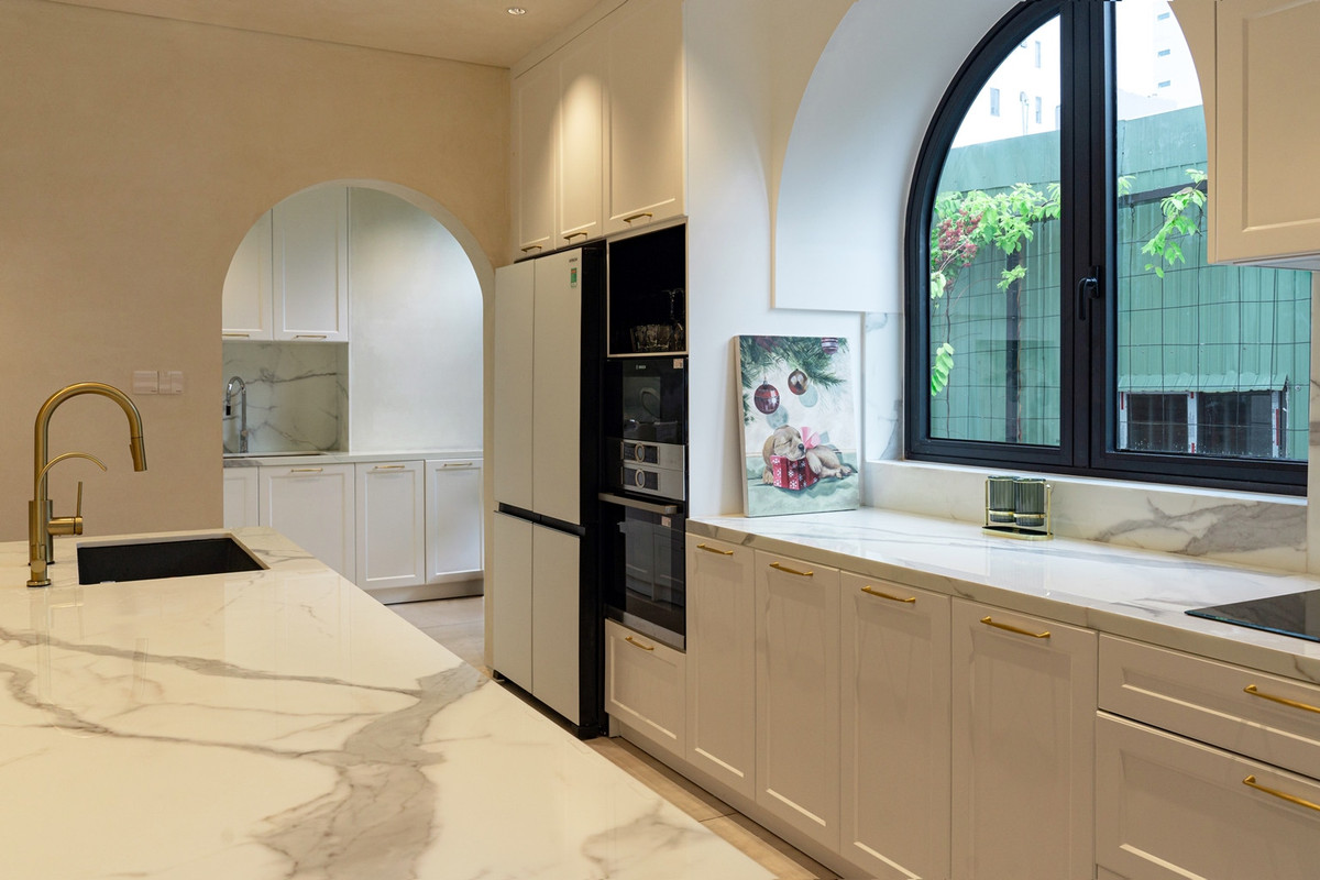 Không gian bếp thoáng đãng với thiên nhiên bên ngoài; khu vực bếp ướt và khu nấu chính ngăn cách bởi ô cửa hình mái vòm. 