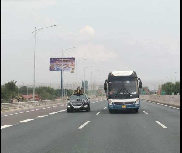 Trong bức ảnh này, tài xế cũng mở cửa sổ trời cho các cháu bé hóng gió dù bên cạnh là 1 chiếc xe khách đang chạy.