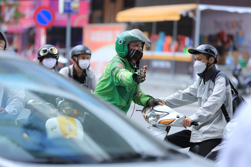 Hình ảnh anh tài xế hướng dẫn người đi đường di chuyển tránh ùn tắc.