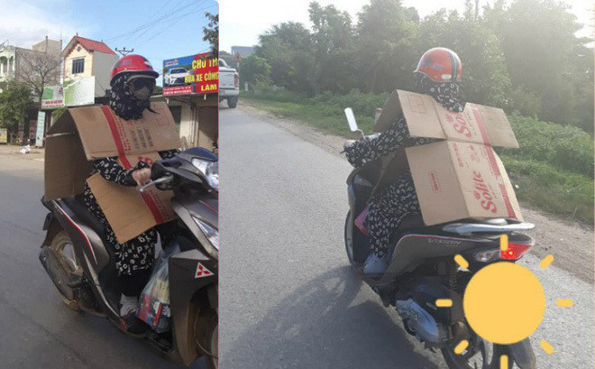 Quần áo, mũ nón là chưa đủ, nên người phụ nữ tận dụng luôn tấm bìa giấy làm chiếc "khiên chống nắng".