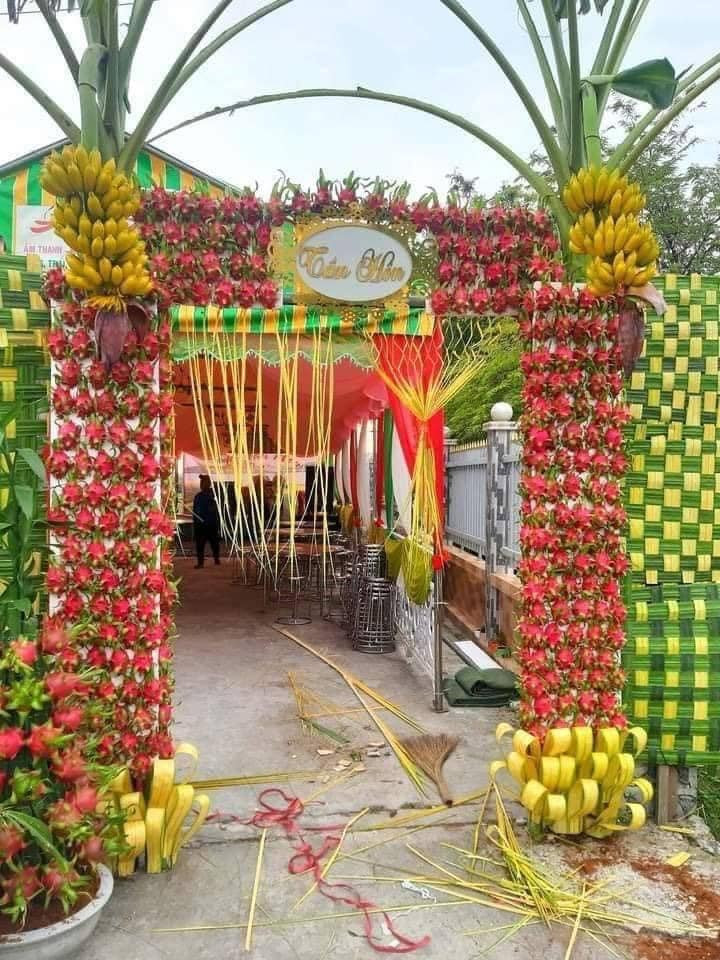 Một chiếc cổng cưới ở Long An đã được cư dân mạng chia sẻ rất nhiều vì yếu tố độc đáo, cổng không làm từ hoa hay lá dừa mà lại trang trí bằng thanh long và chuối.
