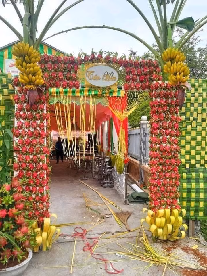 Một chiếc cổng cưới ở Long An đã được cư dân mạng chia sẻ rất nhiều vì yếu tố độc đáo, cổng không làm từ hoa hay lá dừa mà lại trang trí bằng thanh long và chuối.