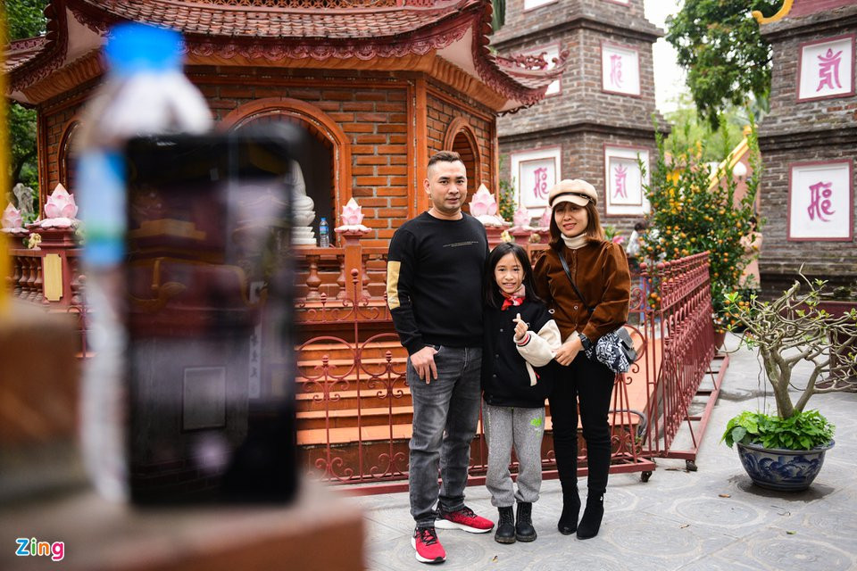 Chị Minh Anh cùng chồng và con gái tới chùa Trấn Quốc chia sẻ: "Gia đình tôi đi từ Chương Mỹ lên đây để lễ chùa đầu năm mới. Trong sân cúng đông quá nên vợ chồng thắp hương cầu bình an, ra chụp kiểu ảnh kỷ niệm rồi về sớm. Dịch bệnh căng thẳng nên đông đúc quá tôi cũng lo".