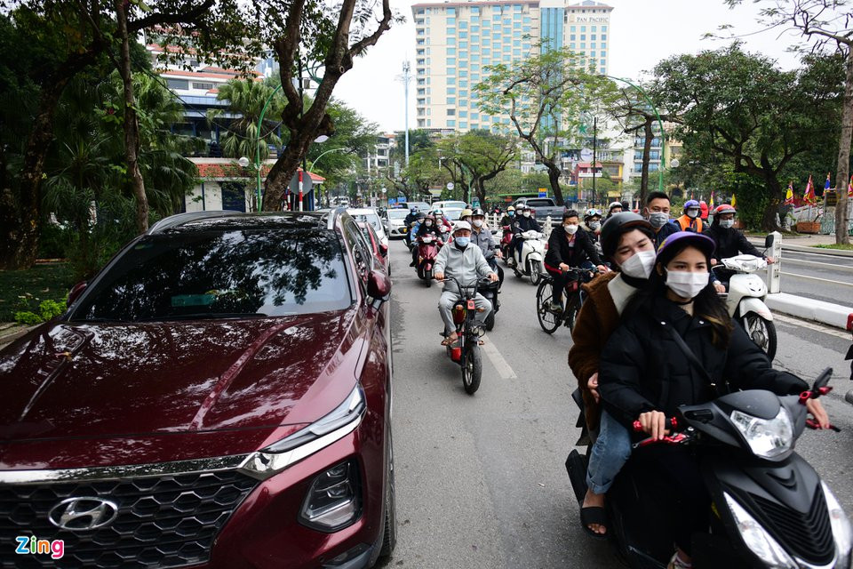 Dưới lòng đường Thanh Niên, phía trước lối vào chùa Trấn Quốc có hàng dài ôtô đỗ của du khách. Giao thông ở đây trở nên lộn xộn và gây ùn tắc khi có ôtô đi qua.