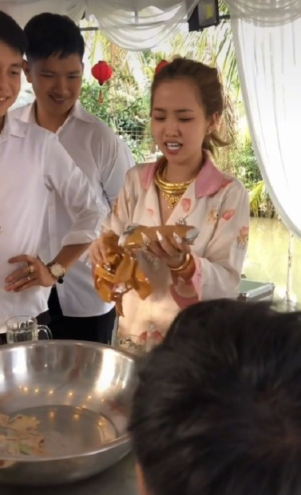 Dù gỡ quà cưới hơi mất công nhưng cô dâu vẫn nở nụ cười tươi rói đủ biết tình cảm của cô dâu và nhóm bạn tốt thế nào. Ảnh: TikTok C.J