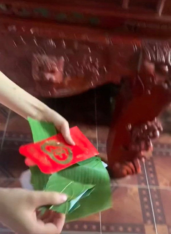 Lần này không phải lá chuối mà là lá sung bọc món quà khiến cô dâu cũng phải “cạn lời” mà phì cười. Ảnh: Cắt từ clip TikTok V.J