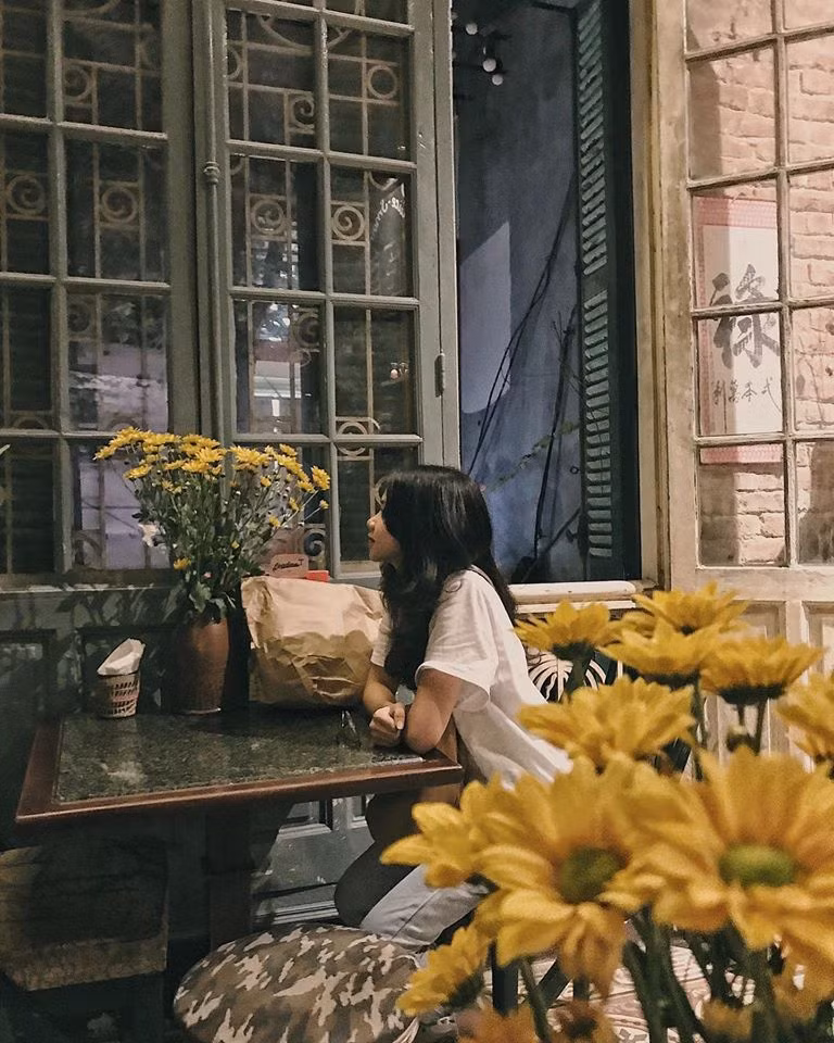 Những bộ bàn ghế gỗ, nền gạch hoa cổ, sofa tối màu, bức tường gạch không sơn,...lại tạo nên tổng thể rất hài hòa. Ảnh: Facebook