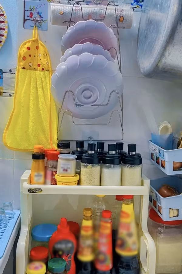 Xoong, nồi, bát đũa cũng được treo lên cao. Còn đối với các loại gia vị nấu ăn, chị đều chiết vào hũ thuỷ tinh và bày gọn gàng trên khay đựng.