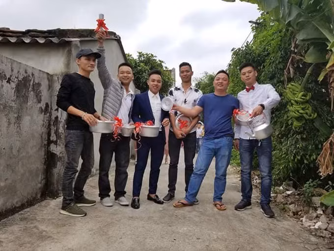 6 người bạn thân của chú rể đã chuẩn bị xoong nồi, chày cối, ấm đun nước làm quà cưới kèm phong bì tiền mừng.