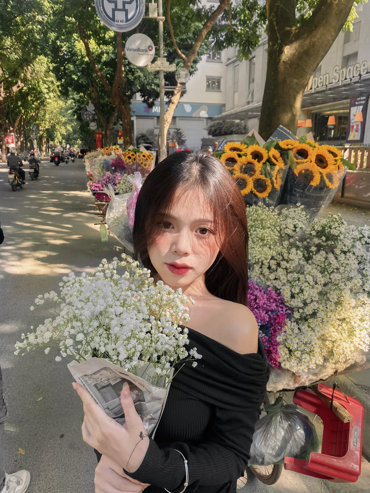 Nhờ đông đảo người dân đến chụp ảnh, người bán hoa bên đường được dịp đắt khách, hai bên đường là dãy gánh hàng hoa đủ màu sắc thu hút người qua lại. Ảnh: Phạm Trang Nhung