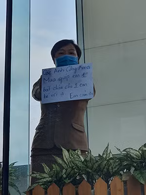 "Các anh Công an ơi! Mua giúp em 1 bát cháo cho 1 em bé với ạ! Em cám ơn" - Một người trong điểm cách ly khách sạn Vanda, Đà Nẵng giơ tờ giấy A4 lên nhờ sự giúp đỡ của Công an vì trong khu cách ly có trẻ con.