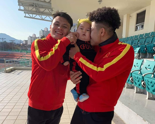 Đức Chinh và Quang Hải phấn khích cứ bám dính lấy cậu bé, không ai chịu nhường ai bế dù mặt cậu bé có vẻ đã rất khó chịu.