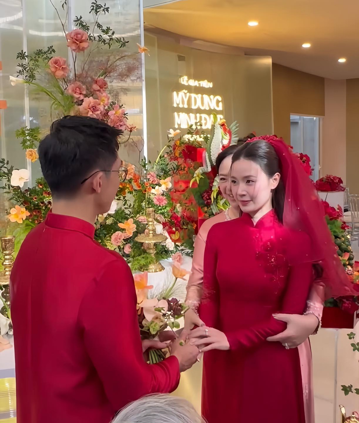 Cặp đôi chọn áo dài đỏ thiết kế riêng, có hoạ tiết hoa mơ của NTK Dũng Nguyễn.