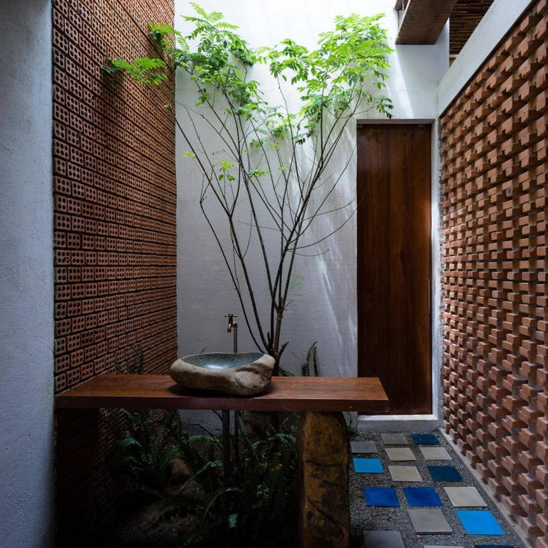 Một chậu rửa tay đặt ở khu vực giếng trời, tạo cảm giác gần gũi và kết nối.