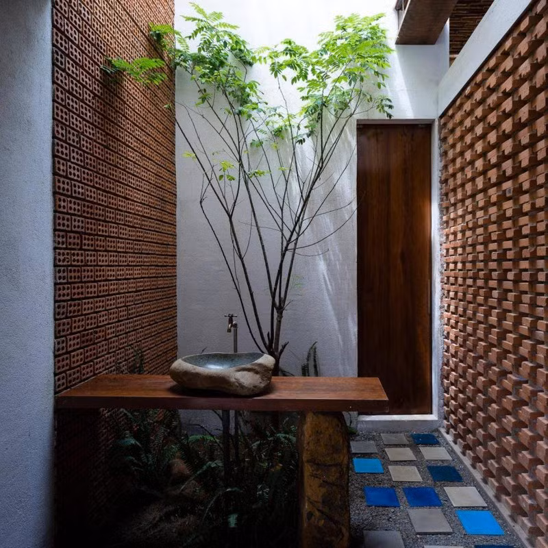 Một chậu rửa tay đặt ở khu vực giếng trời, tạo cảm giác gần gũi và kết nối.