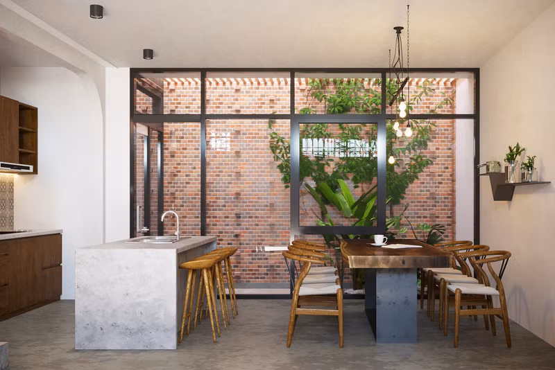 Bộ bàn ghế ăn đặt cạnh cửa trượt, nhìn thẳng ra khu vườn bên ngoài.