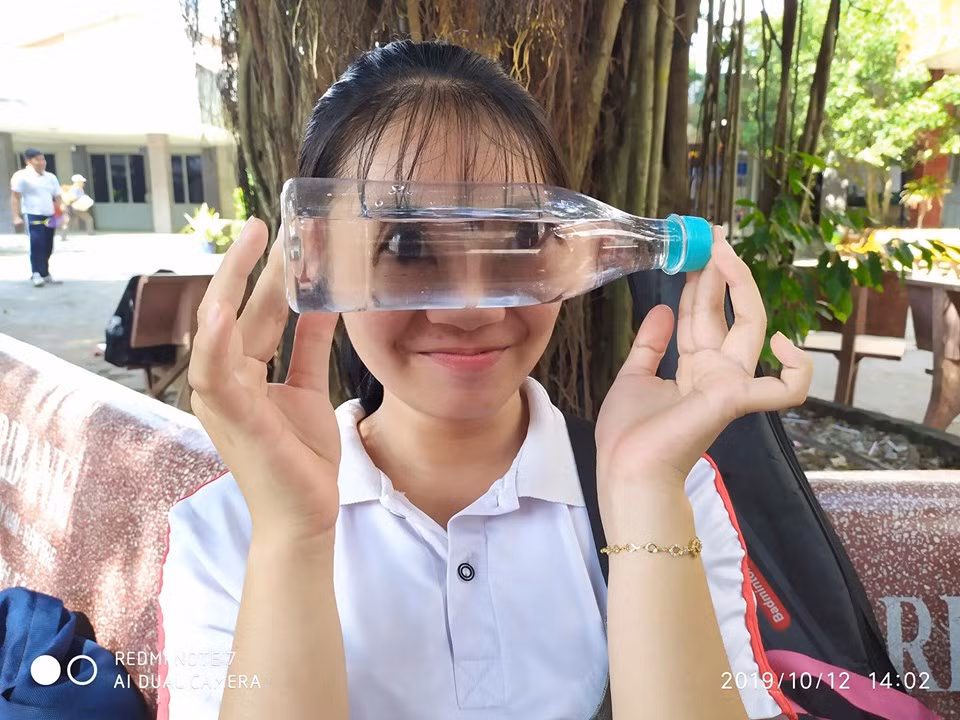 Trong những bức hình này, các bạn học sinh cầm ngang 1 chai nước và để sát trên các vị trí của gương mặt.