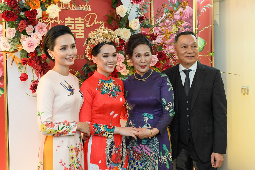 Trong lễ ăn hỏi, cặp đôi cô dâu, chú rể thay hai bộ áo dài đều mang sắc đỏ - gam màu chủ đạo trong đám cưới. Hai bộ trang phục được đánh giá khá cầu kỳ với hoa văn thêu, cầu vai đính rồng phượng và đặc biệt là hai chiếc mấn đội đầu của Quỳnh Anh đều cực kỳ lồng lộn, đính hoa ngọc chi chít.