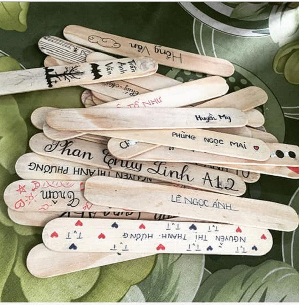 Những chiếc que được dùng để ghi tên là những que kem gỗ hoặc que đè lưỡi bằng gỗ trong nha khoa. Mỗi bạn sẽ tự trang trí và ghi tên của mình lên que.