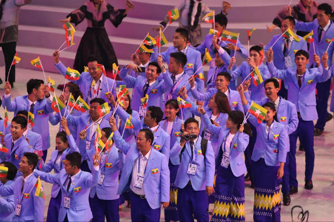 Đoàn thể thao Myanmar với trang phục vest xanh và chân váy truyền thống.