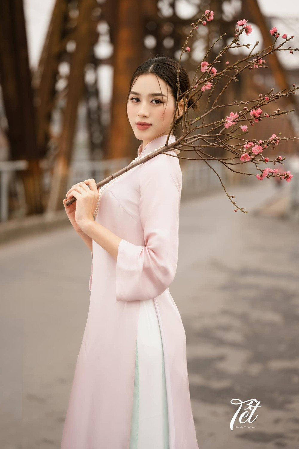 Mỗi độ một mùa hoa khác nhau về, hoa hậu Đỗ Thị Hà đều thực hiện cho mình những bộ ảnh mang chất thơ Hà Nội. Trong bộ ảnh đón tết, Đỗ Thị Hà chọn bối cảnh ở cầu Long Biên cổ kính, đậm không khí hoài cổ. Chọn một bộ áo dài lụa màu hồng nhạt, búi tóc theo kiểu phụ nữ Hà Nội xưa là nhìn nàng hậu đã mang đầy khí chất tiểu thư cổ điển.