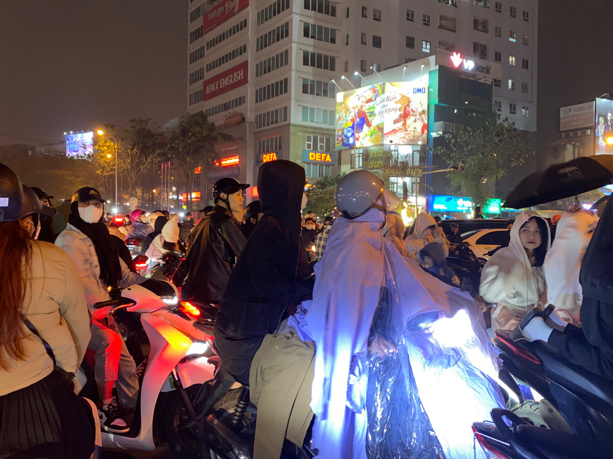 Từ khoảng 19h, thời tiết Hà Nội bắt đầu có mưa phùn kém hơi sương ẩm ướt điều này khiến nhiều người dân phải mặc áo mưa để chờ đón màn trình diễn drone.