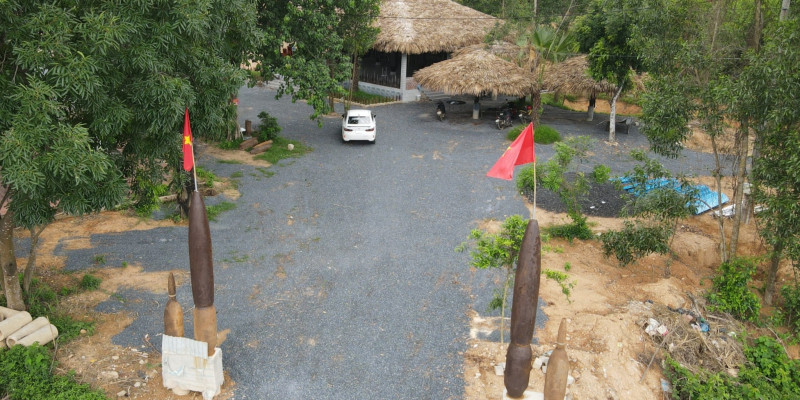 Ngôi nhà bom ngay sau tấm bia đá di tích lịch sử quốc gia đường Hồ Chí Minh Đông Trường Sơn và cây bồ đề của Trung tướng Đồng Sĩ Nguyên trồng khi xây dựng tấm bia đá này.