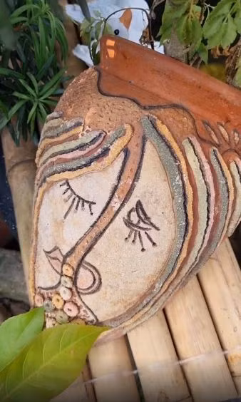 Một chiếc bình có họa tiết như một gương mặt có 1 nửa khóc, 1 nửa cười.