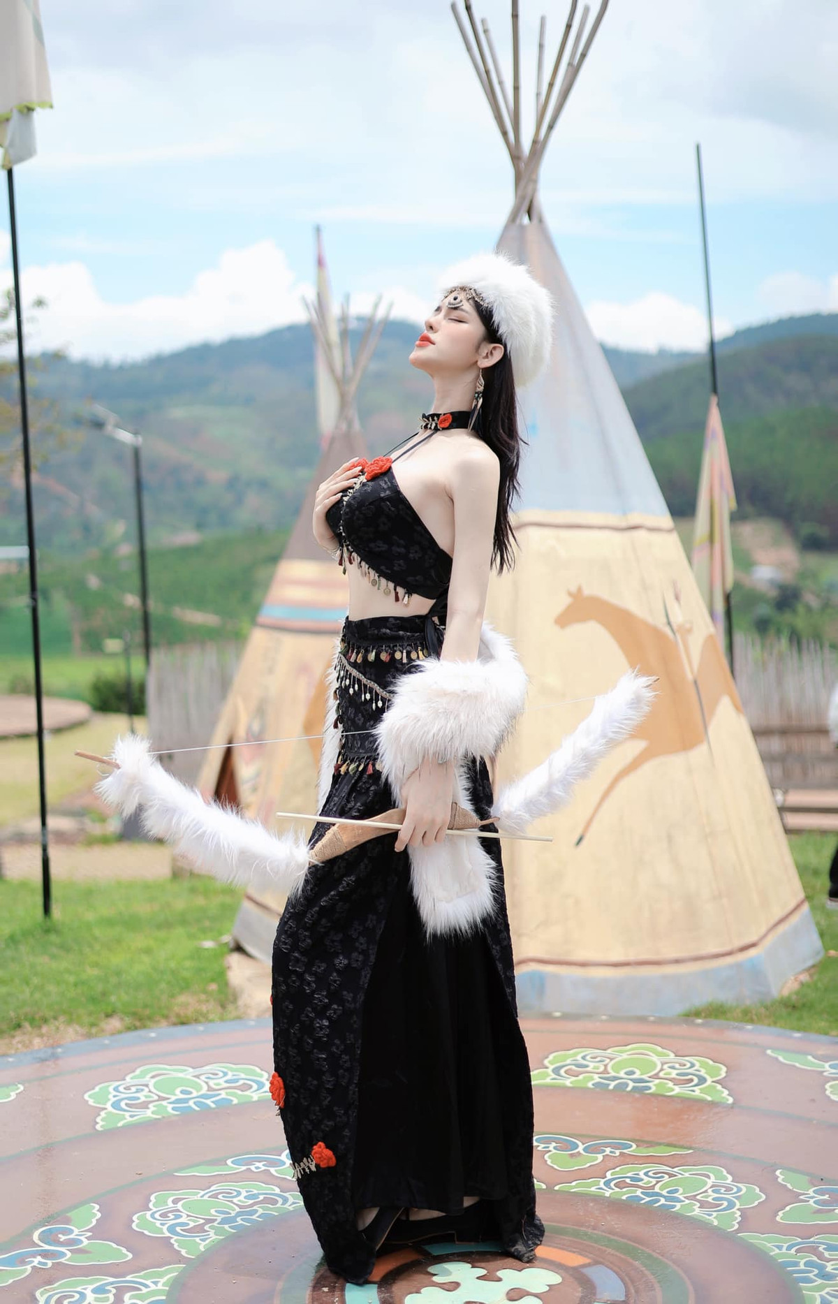 Cầm trong tay chiếc cung tên cũng được quấn lông, Trần Đức Bo tạo dáng khoe đường cong cơ thể.