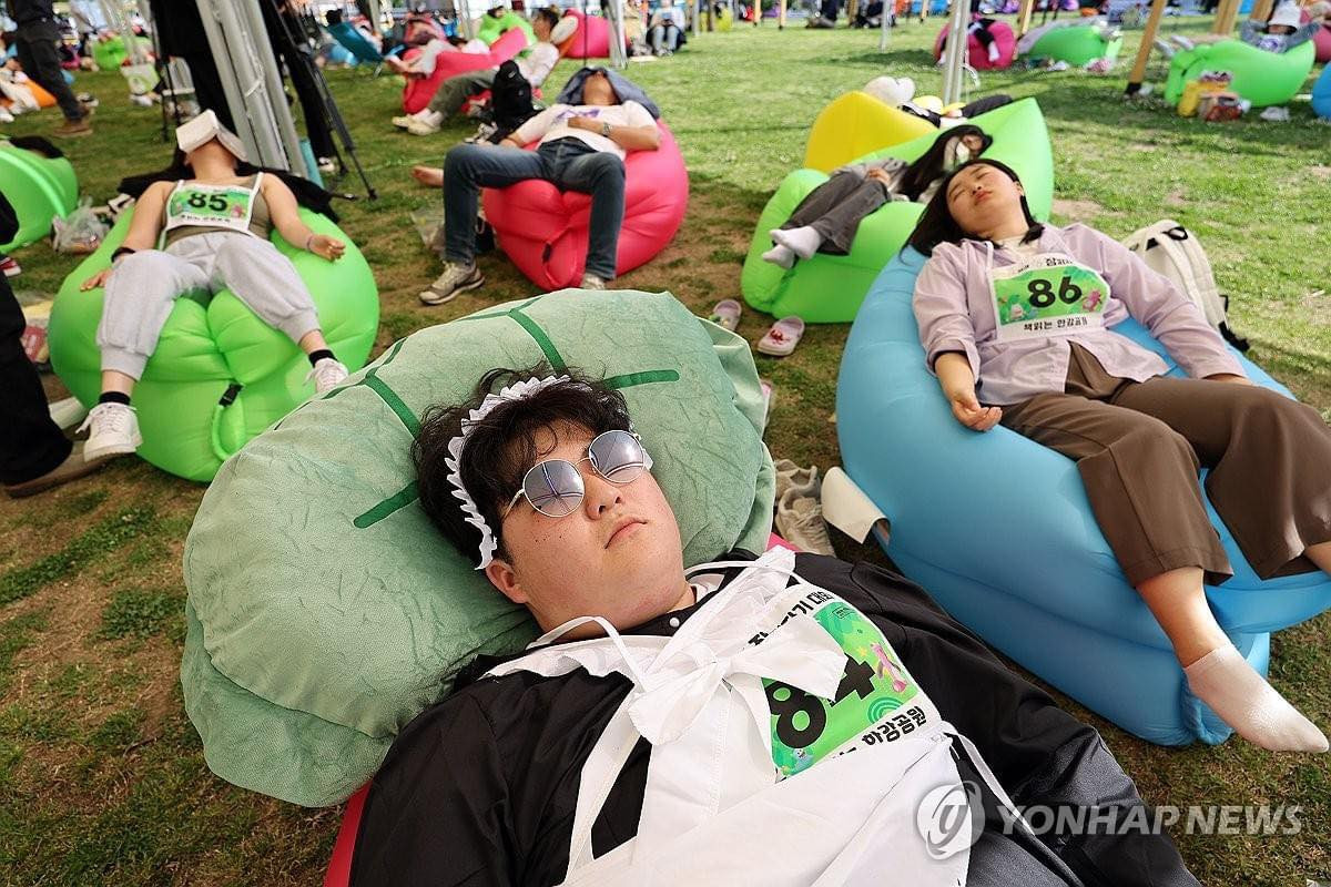 100 người dân đã tập trung tại quảng trường cây xanh trong công viên Yeouido (Seoul, Hàn Quốc) để tham gia "Cuộc thi ngủ trên sông Hàn 2024" được tổ chức bởi thành phố Seoul.