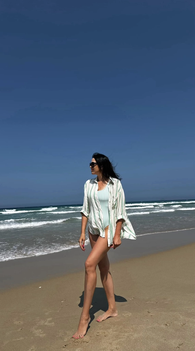 Trong ảnh, mẹ vợ của Bùi Tiến Dũng diện trang phục bikini liền thân màu xanh, khoe trọn đôi chân dài miên man.