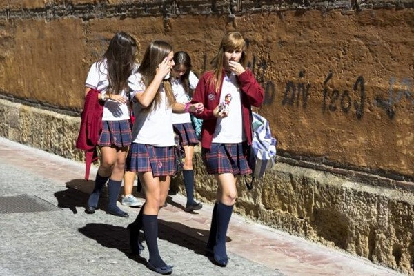 Học sinh tại cộng đồng tự trị Castilla và León, Tây Bắc Tây Ban Nha, trông thời trang trong bộ đồng phục thống gồm tất dài màu đen, váy kẻ xếp ly, áo thun trắng và áo khoác mỏng gắn logo trường.