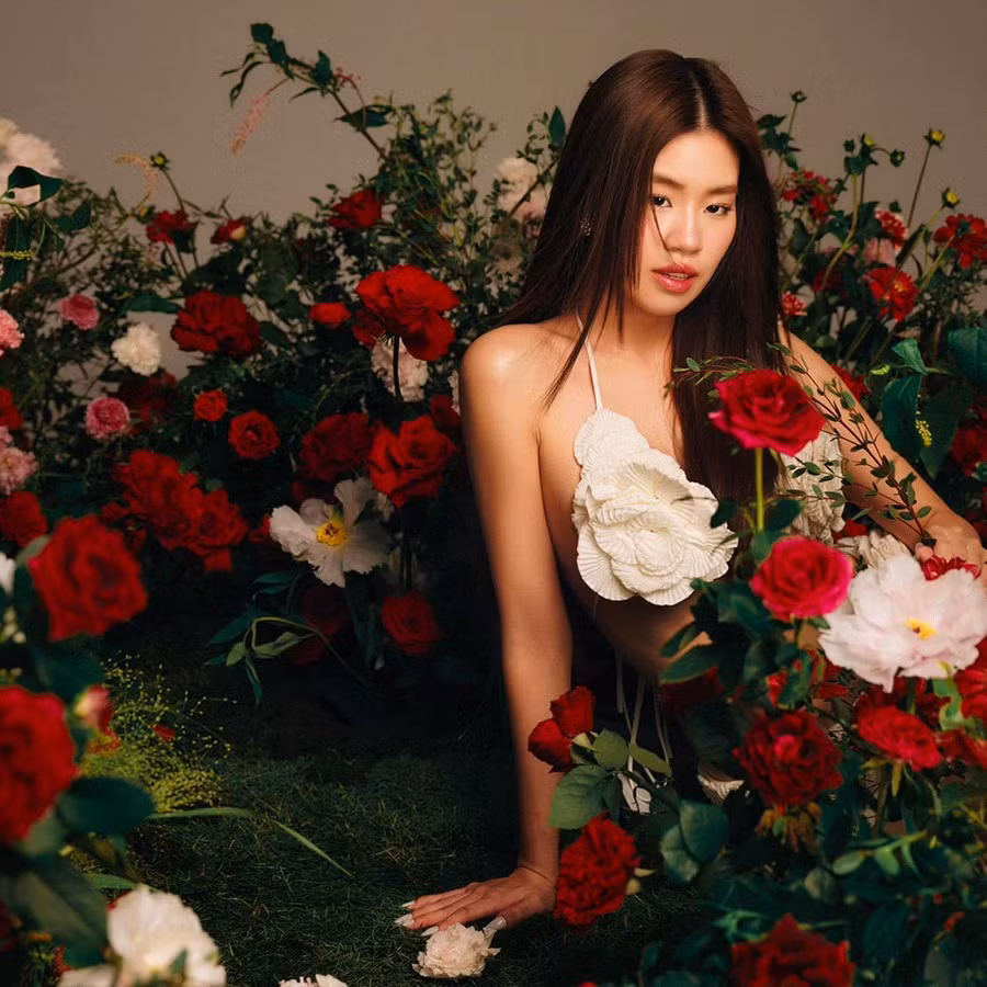 Cô nàng để tóc thẳng, tạo dáng giữa rừng hoa tạo nên vẻ đằm thắm, bí ẩn.