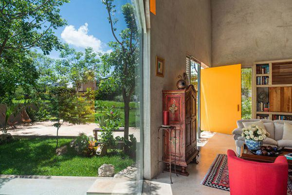 Phòng khách mang thiết kế châu Âu nhẹ nhàng theo mong muốn của người vợ. Từ đây, ta có thể nhìn ra khu vườn rộng lớn bên ngoài qua lớp của kính khổ lớn.