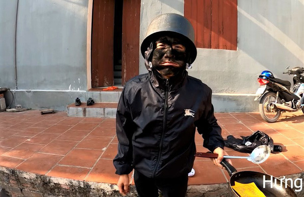 Theo đó, Hưng Vlog bôi nhọ đen xì mặt, đội nồi cơm điện, mặc bộ đồ màu đen và cầm chảo tới đi vào nhà xin tiền bà Tân. Quá hoảng sợ trước hình dạng quái dị nên bà Tân buộc phải cho tiền.