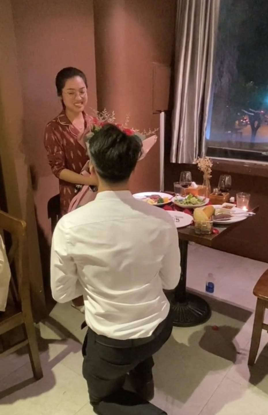Cháng trai quỳ xuống và cầu hôn bạn gái. Bạn gái rất bất ngờ và trông khá sượng.