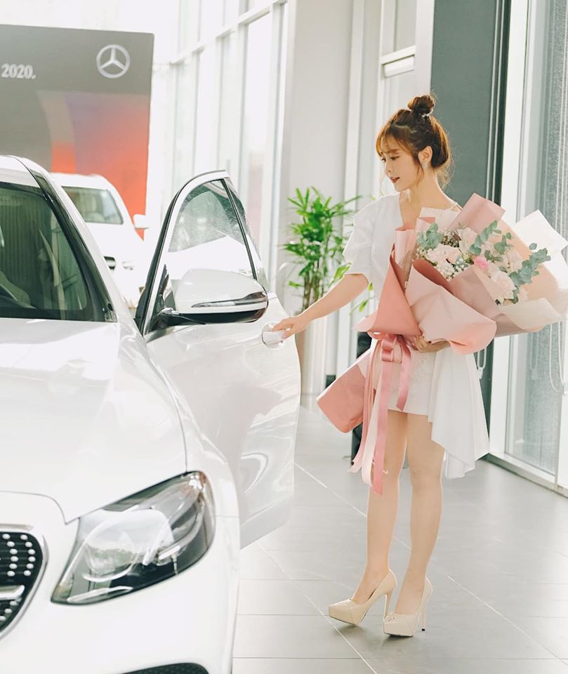 Trong ngày bàn giao xe mới, cô nàng diện bộ đồ màu trắng ton - sur - ton với màu chiếc xe hạng sang.