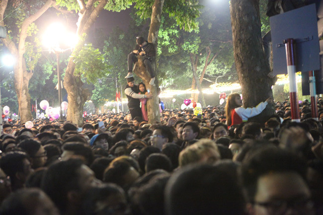 Để có một vị trí đắc địa theo dõi lễ hội, nhiều bạn trẻ không ngần ngại đu cây, trèo lên tường. Đây là hành động cực kỳ xấu và gây mất mĩ quan đô thị.