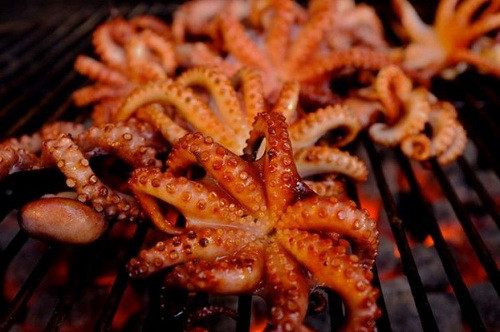 Mực nướng Hàng Bồ. Những quán mực nướng trên con phố này chỉ hoạt động nhộn nhịp vào khoảng 21h-22h trở đi. Một cái bếp than hoa nhỏ, một mẹt mực khô cùng vài chiếc chiếu, thế là bất cứ nơi đâu trên con phố này đã có thể mọc lên một tiệm mực nướng.