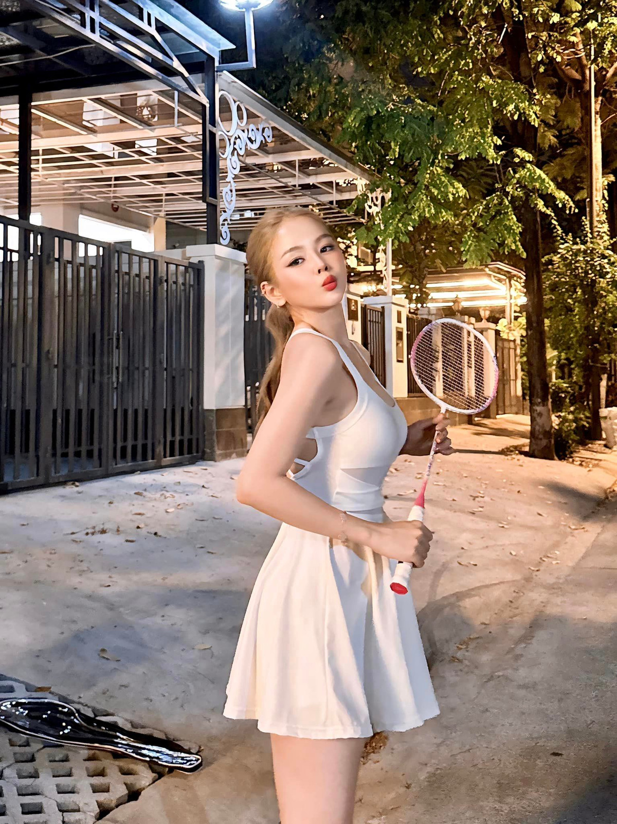 Có vẻ như chiếc vợt cầu lông màu hồng đặc biệt này vừa được cô nàng "khui hộp" khi túi đựng vợt vẫn để ở phía sau.