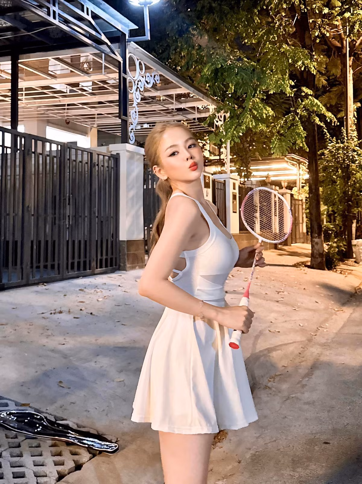 Có vẻ như chiếc vợt cầu lông màu hồng đặc biệt này vừa được cô nàng "khui hộp" khi túi đựng vợt vẫn để ở phía sau.