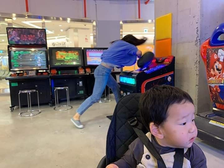 Người mẹ trẻ chơi trò chơi với biểu cảm hết sức hài hước, chơi hết mình trông cũng vô cùng hết hồn. Trong khi đó, cậu bé ngồi yên lặng, gương mặt lộ rõ vẻ chán nản nhưng vẫn nhẫn nại.