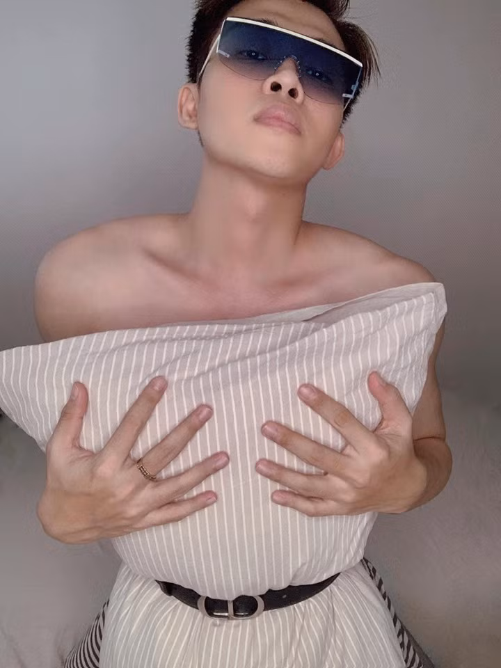 "Trùm cuối" trong trào lưu lần này có lẽ là stylist Trần Đạt, anh chàng là sao nam Vbiz duy nhất tham gia thử thách #Quarantinepillowchallenge. Stylist tạo dáng ngồi trên giường, dùng chiếc gối kẻ sọc và đeo thắt lưng Dior. (Ảnh: FBNV)