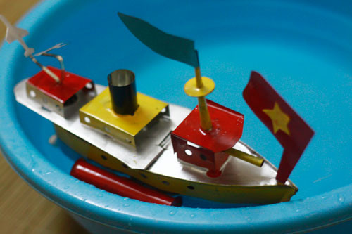 Làm từ vỏ lon sữa bò hay mảnh sắt bỏ đi, điểm độc đáo của món đồ chơi này có thể chạy trên mặt nước như tàu thuỷ thứ thiệt. Ảnh: thoibaotaichinh.vn