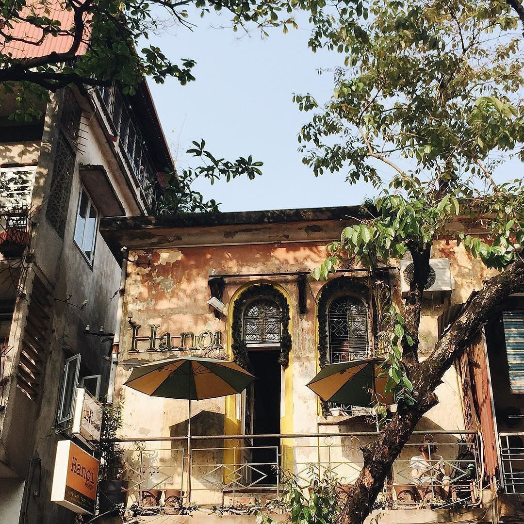 Dòng chữ Hanoi nổi bật trên nền tường vàng phủ rêu được xem như tấm biển quảng cáo đặc trưng của quán.
